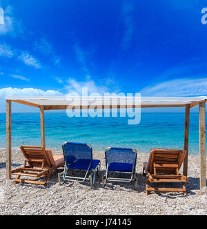 Sommer-morgen-Strand mit türkisblauem Wasser und Sonnenliegen (Albanien). Zwei Schüsse feststeppen Bild mit hoher Auflösung. Stockfoto