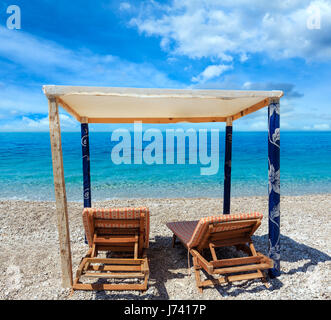 Sommer-morgen-Strand mit türkisblauem Wasser und Sonnenliegen (Albanien). Zwei Schüsse feststeppen Bild mit hoher Auflösung. Stockfoto