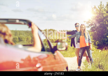 paar Trampen und Anhalten von Autos auf Land Stockfoto