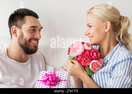 Brautpaar mit Geschenk-Box im Bett zu Hause Stockfoto