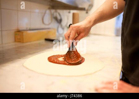 Kochen mit Tomatensoße, Pizza in der Pizzeria Stockfoto