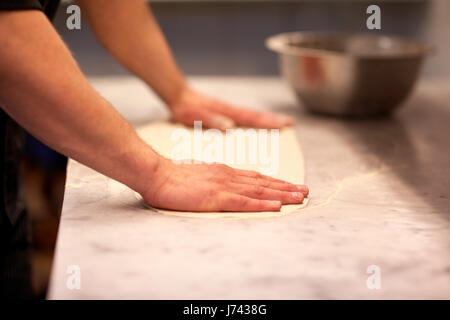 Koch die Hände Zubereitung Teig am Tisch in der Küche Stockfoto