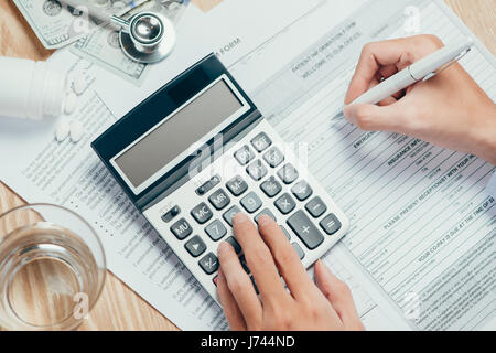 Hand schreibt die persönlichen Informationen auf die Krankenversicherung Antragsformular Stockfoto