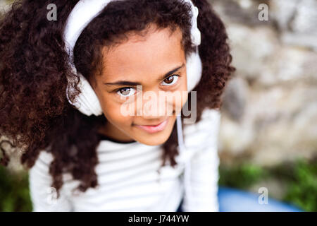 Schöne afrikanische amerikanische Mädchen mit Kopfhörer, Musik hören. Stockfoto