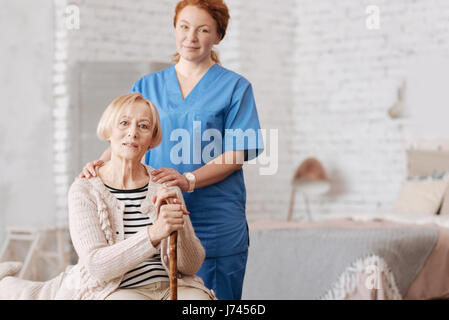 Qualifizierte private Krankenschwester, die Unterstützung von älteren Patienten Stockfoto