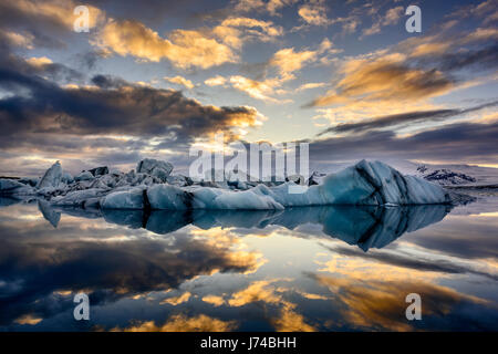 Blaue und schwarze Eisberge schwimmt auf der Gletscherlagune Jokullsarlon bei Sonnenuntergang. Stockfoto