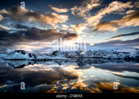 Blaue und schwarze Eisberge schwimmt auf der Gletscherlagune Jokullsarlon bei Sonnenuntergang. Stockfoto