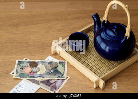 Japanische Teekanne auf Bambus tablett mit Yen und Restaurant. Stockfoto