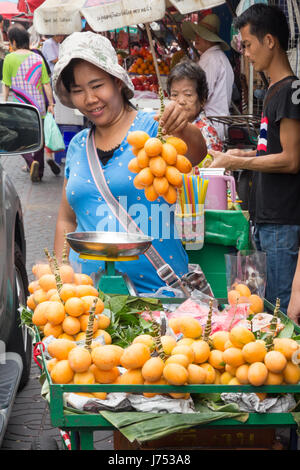 Frau Straßenhändler hält eine Reihe von frischem Obst Bangkok thailand Stockfoto