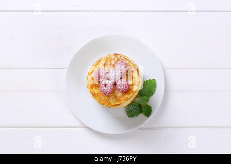 Stapel von amerikanische Pfannkuchen mit frischen Himbeeren auf weißen Teller Stockfoto