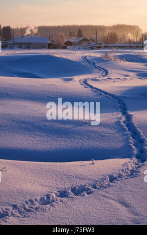 Wanderweg-Spuren im Schnee im russischen Altai-Dorf im Winter jeweils Morgen, Sibirien, Russland Stockfoto