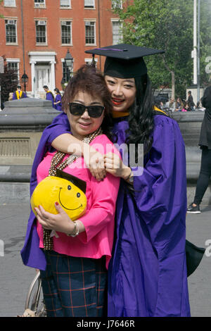 Eine chinesische Gaststudent feiern ihr Abitur am NYU mit einer Frau, die zu ihrer Mutter zu sein scheint. Im Washington Square Park in New York City Stockfoto