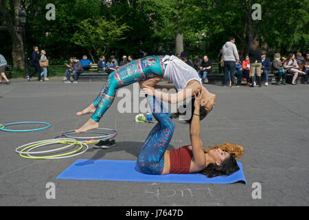 Zwei hübsche junge Damen tun Acroyoga im Washington Square Park in Greenwich Village, New York City. Stockfoto