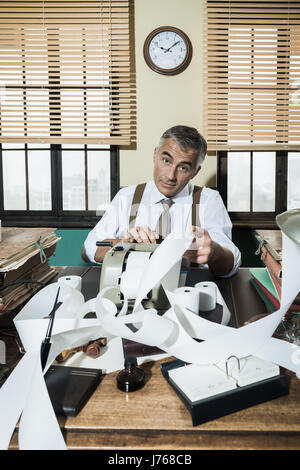 Beschäftigt Vintage Buchhalter mit Rechenmaschine Kasse Band umgeben. Stockfoto