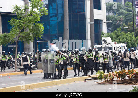 Polizeibeamte nutzen Tränengas ein Kautschuk gegen Demonstranten während einer Protestaktion gegen die Regierung von Nicolas Maduro in Caracas zu pellets. Stockfoto