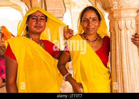 Zwei Putzfrauen im Amber Fort in Jaipur, Indien, in gelben Kleidern im Maharaja Palace, Kleider weiblich gelb Reinigung Fort. Stockfoto