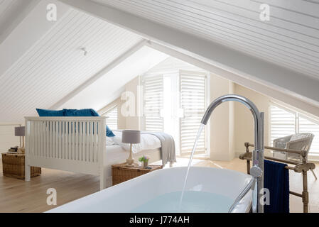 Freistehende Badewanne im Obergeschoss Schlafzimmer mit schrillen Decke und Fensterläden. Geschenkkörbe von Fortnum & Mason wurden als Nachttische verwendet Stockfoto