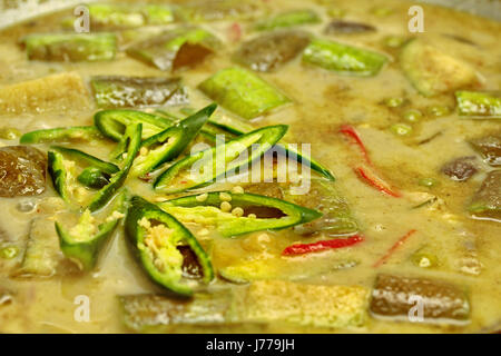 Hausgemachte grüne Hühnchen-Curry in Kokosmilch mit langen Aubergine in der Pfanne kochen. Stockfoto