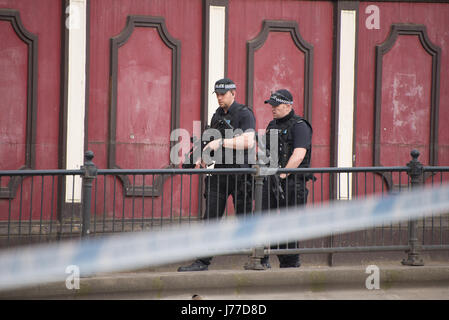 Manchester, UK. 23. Mai 2017. Bewaffnete Polizisten patrouillieren die abgesperrten Bereich außerhalb der Arena Manchester in Manchester, Grossbritannien am Dienstag, 23. Mai 2017. Polizei des Großraums Manchester behandeln die Explosion nach dem Ariana Grande-Konzert, das am 22.05.2017 in Manchester Arena stattfand, als eines terroristischen Anschlags. Bildnachweis: Jonathan Nicholson/Alamy Live-Nachrichten Stockfoto