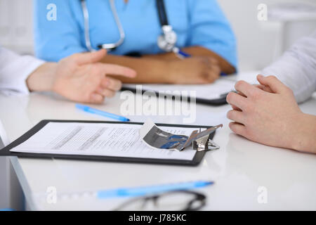 Zwei Ärzte und männlichen Patienten, die medizinische Vorgeschichte diskutieren Stockfoto