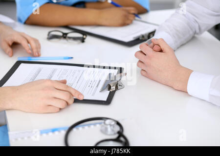Zwei Ärzte und männlichen Patienten, die medizinische Vorgeschichte diskutieren Stockfoto