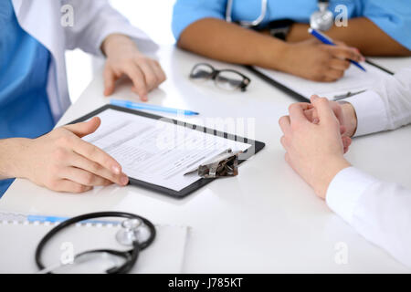 Zwei Ärzte und männlichen Patienten, die medizinische Vorgeschichte diskutieren Stockfoto