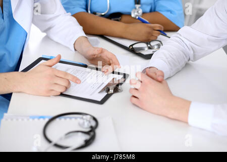 Zwei Ärzte und männlichen Patienten, die medizinische Vorgeschichte diskutieren Stockfoto