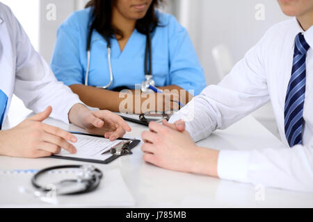 Zwei Ärzte und männlichen Patienten, die medizinische Vorgeschichte diskutieren Stockfoto