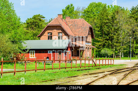 Brosarp, Schweden - 18. Mai 2017: Dokumentation der öffentlichen historischen Ort. Das alte Bahnhofsgebäude der Oldtimer Eisenbahn mit Plumpsklo und Spuren im Vordergrund Stockfoto