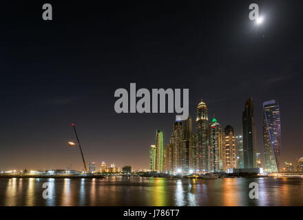 Nachtansicht einer mondhellen Dubai Marina mit Reflexionen in den Hafen. Stockfoto