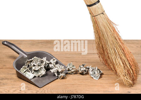 Geld in die Müll-Schaufel Stockfoto