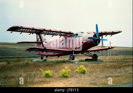 Eine alte, verlassene, rote Ebene steht im Feld. Die Drehscheibe ist blau Stockfoto