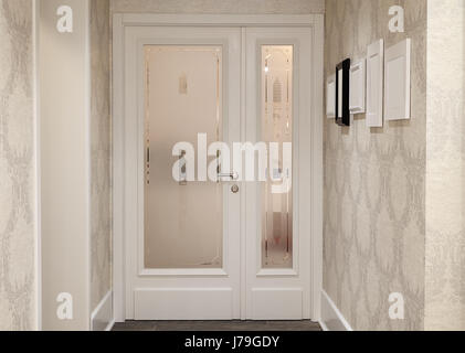 Innen ein modernes und neues Hotel, Details der Empfangsraum, helle Eingangstüren mit Bilderrahmen und dekorative Tapeten. Stockfoto