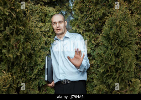 Mann Glatze und das ängstliche Gesicht. Unter dem Arm hält er einen Laptop. Stockfoto