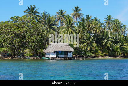 Küste mit tropischer Vegetation und ein rustikales Haus auf Stelzen über dem Wasser, Insel Bastimentos, Bocas del Toro, Panama, Karibik, Mittel- Stockfoto