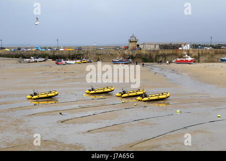 St. Ives, Cornwall, UK - Jollen gehörenden an St Ives Self Drive Boats, Trawler und kleine Yachten in St Ives Hafen bei Ebbe Stockfoto