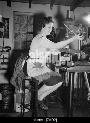 Frau Maschinist platziert Schrauben in elektrische Anschlüsse in ihrem Atelier, 1942. Stockfoto