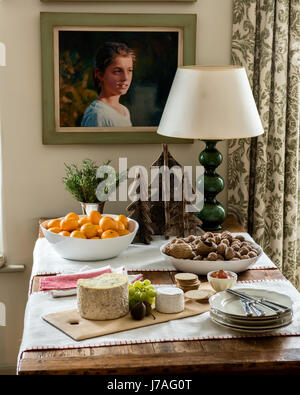 Käse vom Brett, Nüssen und Mandarinen auf einem Holztisch mit dekorativen Weihnachtsbaum Modelle Stockfoto