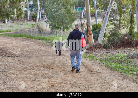 Ganey Aviv - 2. Dezember 2016: ein Mann geht mit seinem Hund im Feld in der Nähe von Ganey Aviv, Israel Stockfoto