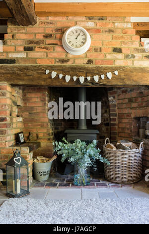 Gemütliches Wohnzimmer mit Kamin Inglenook, Backstein Wand- und hölzerne Balkendecke. Der Teppich ist von John Lewis Stockfoto