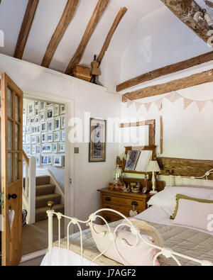 Gewölbte Hauptschlafzimmer mit alten Balken und Schmiedeeisen-Bett aus The Iron Bed company Stockfoto