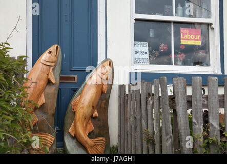 Zwei hölzerne Fische auf ein Tor vor einem Haus in Staithes, North Yorkshire, England, UK Stockfoto