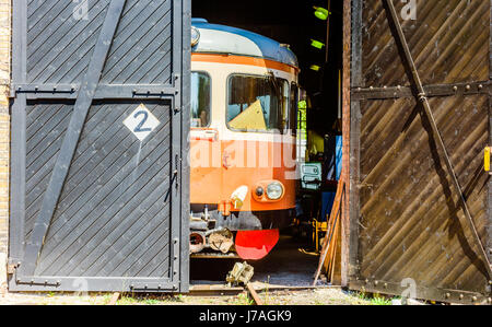 Brosarp, Schweden - 18. Mai 2017: Dokumentation der öffentlichen historischen Bahnhofsbereich. Die Vorderseite des alten orange-Oldtimer-Triebwagen ist sichtbar durch eine ope Stockfoto