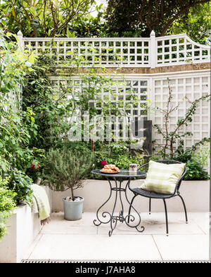 Stuhl und Tisch im Garten des viktorianischen Innenhofterrasse, London Stockfoto