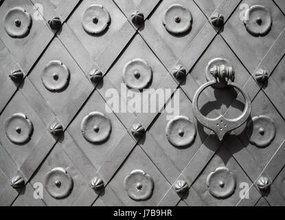 Fragment einer antiken Metall Tür mit dekorativen Griff Ring, Vorderansicht, Hintergrundtextur Stockfoto