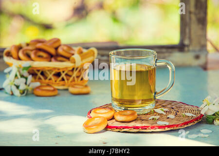 Eine Tasse Kräutertee auf einem Holztisch im Garten Stockfoto