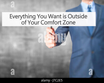 Alles, was Sie wollen ist außerhalb von Your Comfort Zone - Geschäftsmann Hand mit Schild. Wirtschaft, Technologie, Internet-Konzept. Stock Foto Stockfoto