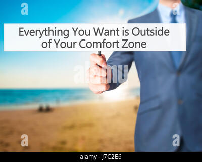 Alles, was Sie wollen ist außerhalb von Your Comfort Zone - Geschäftsmann Hand mit Schild. Wirtschaft, Technologie, Internet-Konzept. Stock Foto Stockfoto