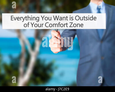 Alles, was Sie wollen ist außerhalb von Your Comfort Zone - Geschäftsmann Hand mit Schild. Wirtschaft, Technologie, Internet-Konzept. Stock Foto Stockfoto
