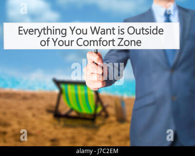 Alles, was Sie wollen ist außerhalb von Your Comfort Zone - Geschäftsmann Hand mit Schild. Wirtschaft, Technologie, Internet-Konzept. Stock Foto Stockfoto